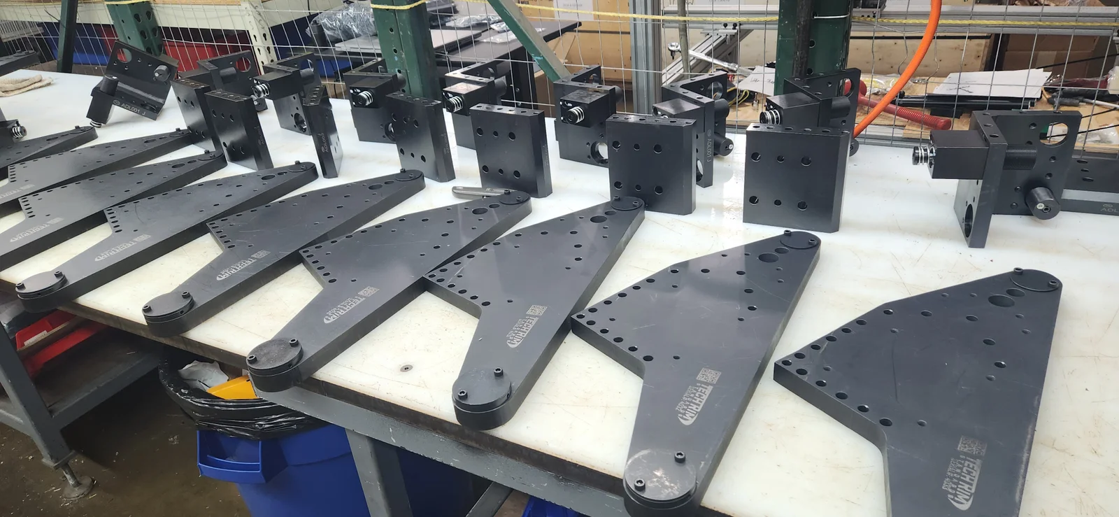 Finished FASTECH sub-unit plates and blocks staged on a shop bench